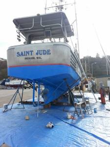 The Saint Jude hauled out in the Port of Port Angeles Boatyard on March, 12, 2015. My husband is in Grundens rain gear working on painting the bottom while our son, a third generation commercial fisherman, heads up the ladder.